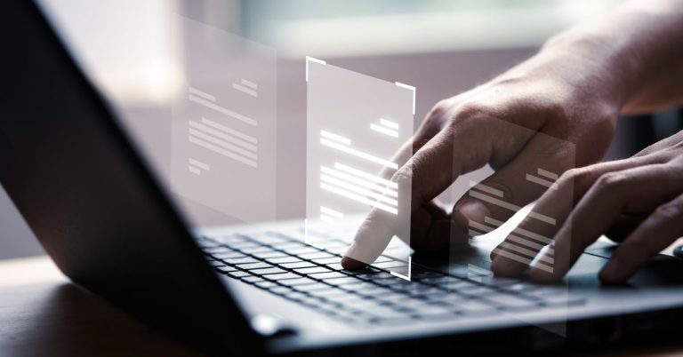 mains qui écrivent sur le clavier d'un ordinateur avec des fiches holographiques